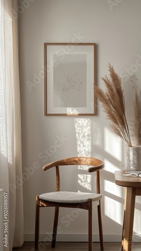 A serene corner featuring a wooden chair, delicate framed artwork and pampas grass, bathed in gentle natural light.