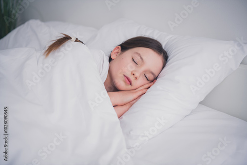 Portrait of beautiful adorable girl lying sleeping enjoying sweet dreams white light room interior indoors