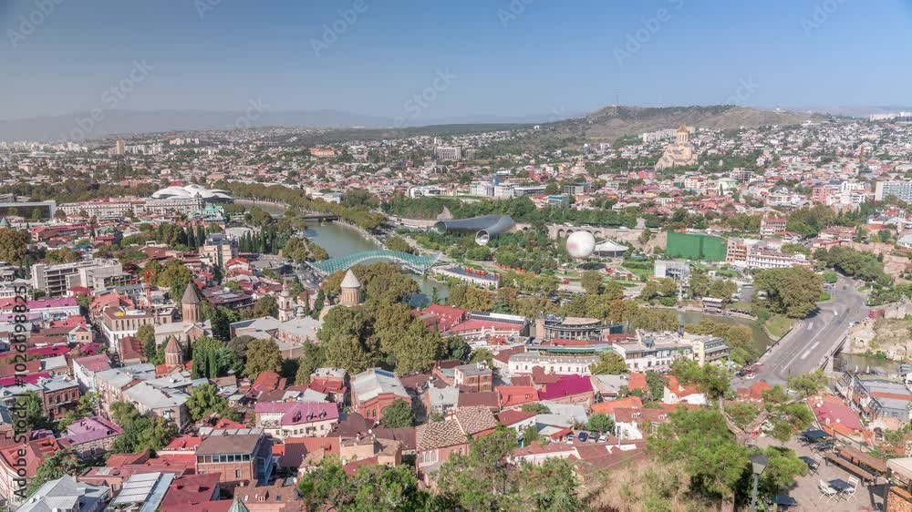 Colorful traditional houses with wooden balconies and red roofs in the Old Town of Tbilisi aerial timelapse, Georgia. View from above with the bridge of peace and river Colorful traditional houses with wooden balconies and red roofs in the Old Town of Tbilisi aerial timelapse, Georgia. View from above with the bridge of peace and river
