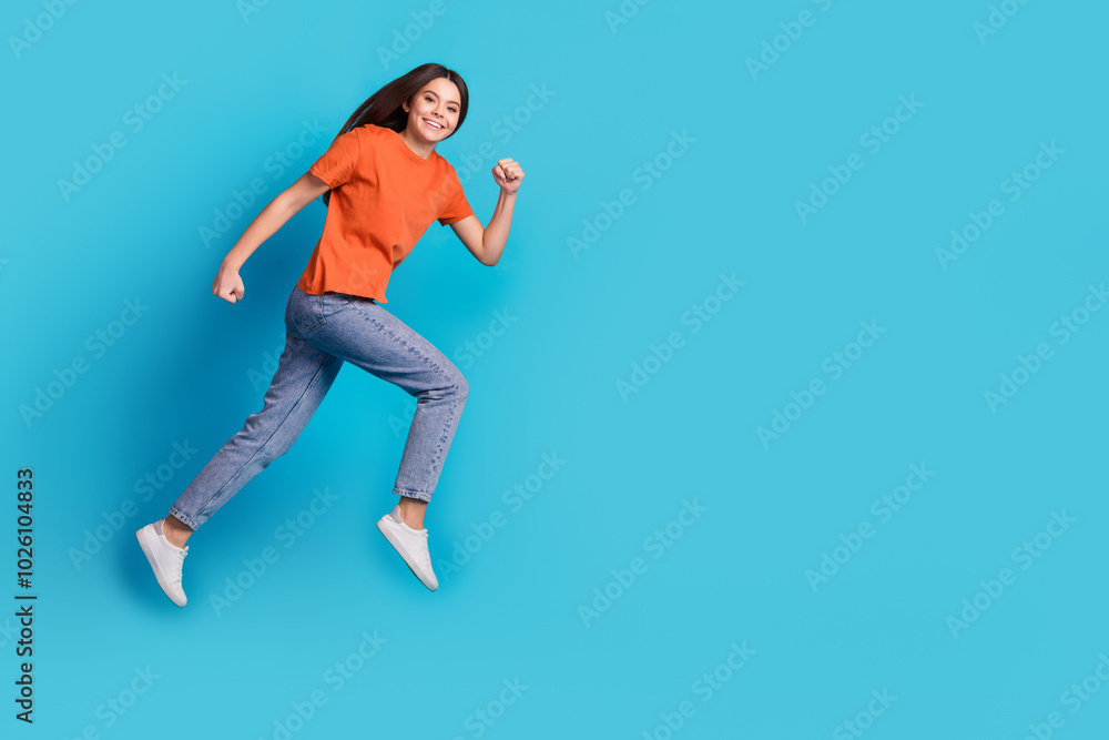 Full size photo of pretty teen girl running hurry black friday wear trendy orange outfit isolated on blue color background Full size photo of pretty teen girl running hurry black friday wear trendy orange outfit isolated on blue color background