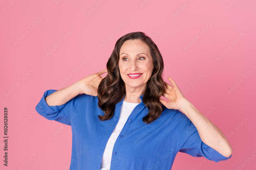 Photo portrait of nice pensioner female look empty space hold hair wear trendy blue outfit isolated on pink color background Photo portrait of nice pensioner female look empty space hold hair wear trendy blue outfit isolated on pink color background