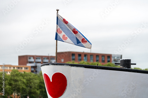 The flag of the province of Friesland, a region in the northern Netherlands. The flag features alternating diagonal stripes of blue and white and seven red 