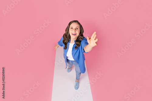 Full length photo of lovely senior lady walk podium stretch hand top view dressed stylish blue garment isolated on pink color background photo