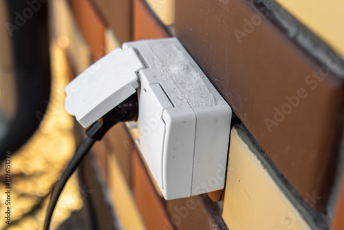Foto Outdoor electrical outlet on the wall of brick house