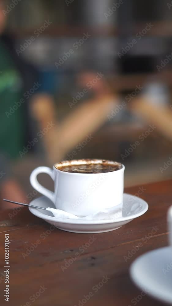 beautiful vertical video portrait of a cup of black coffee being stirred in a white glass beautiful vertical video portrait of a cup of black coffee being stirred in a white glass