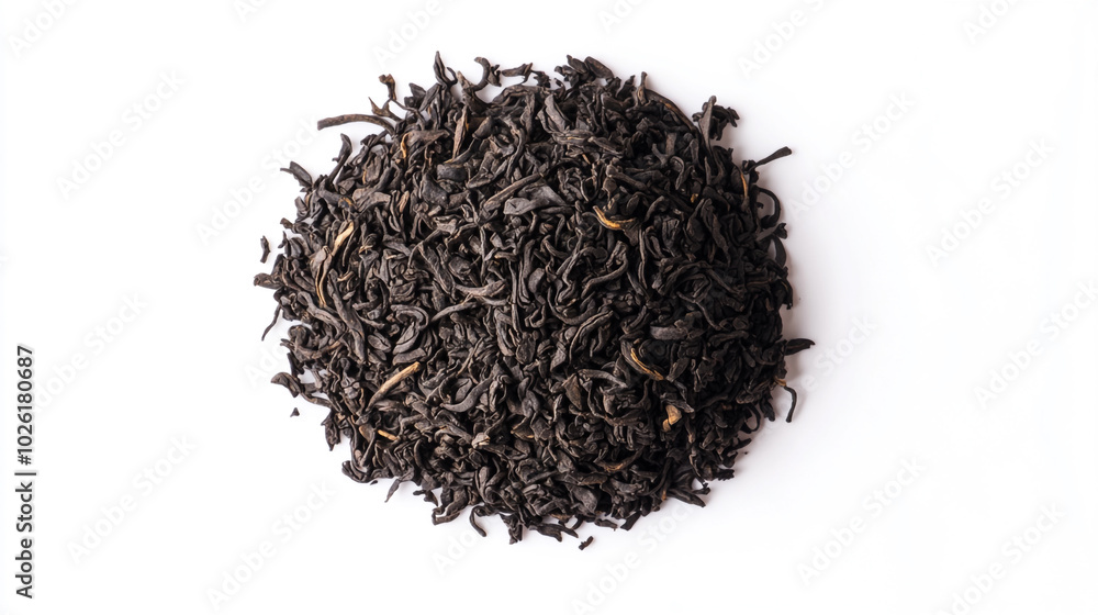 Loose black tea leaves arranged in a circular shape on a white surface Loose black tea leaves arranged in a circular shape on a white surface