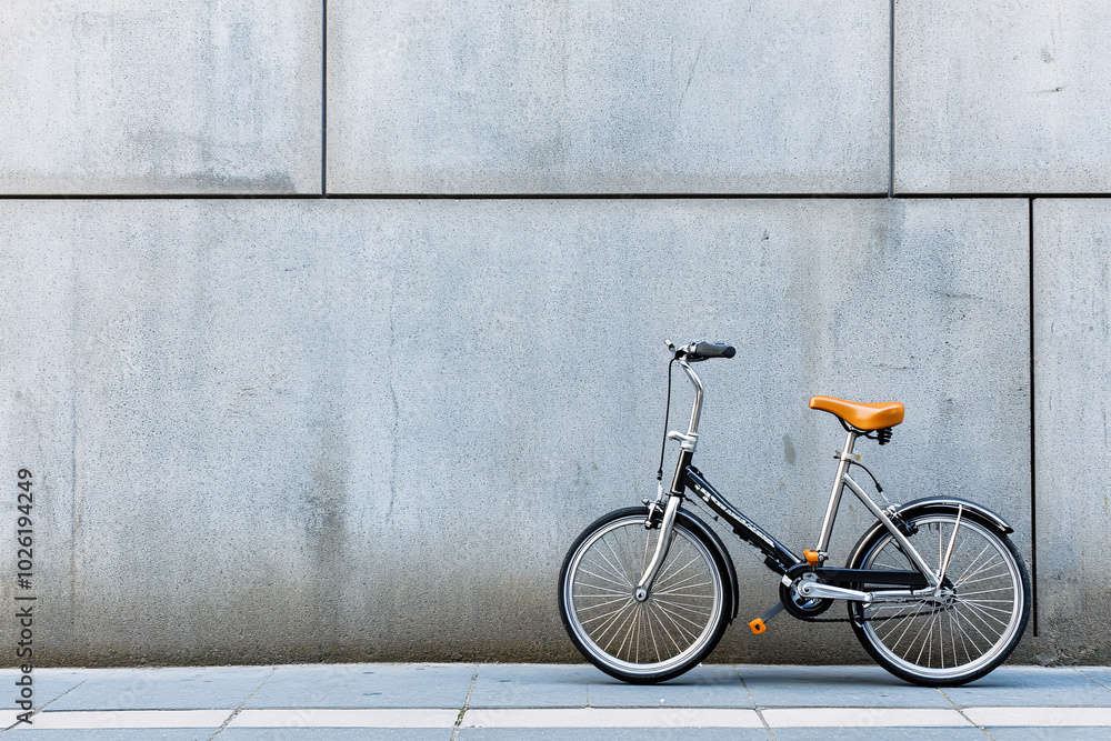 Folding Bike Parked Against a Grey Wall