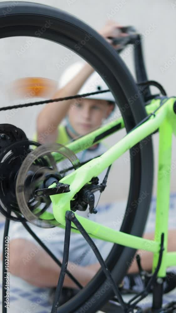 Young Boy Wear Helmet Adjusts Gears on Green Bicycle, Showcasing Enthusiasm For Cycling and Learning About Bike Mechanics in an Outdoor Setting. Vertical Video Young Boy Wear Helmet Adjusts Gears on Green Bicycle, Showcasing Enthusiasm For Cycling and Learning About Bike Mechanics in an Outdoor Setting. Vertical Video