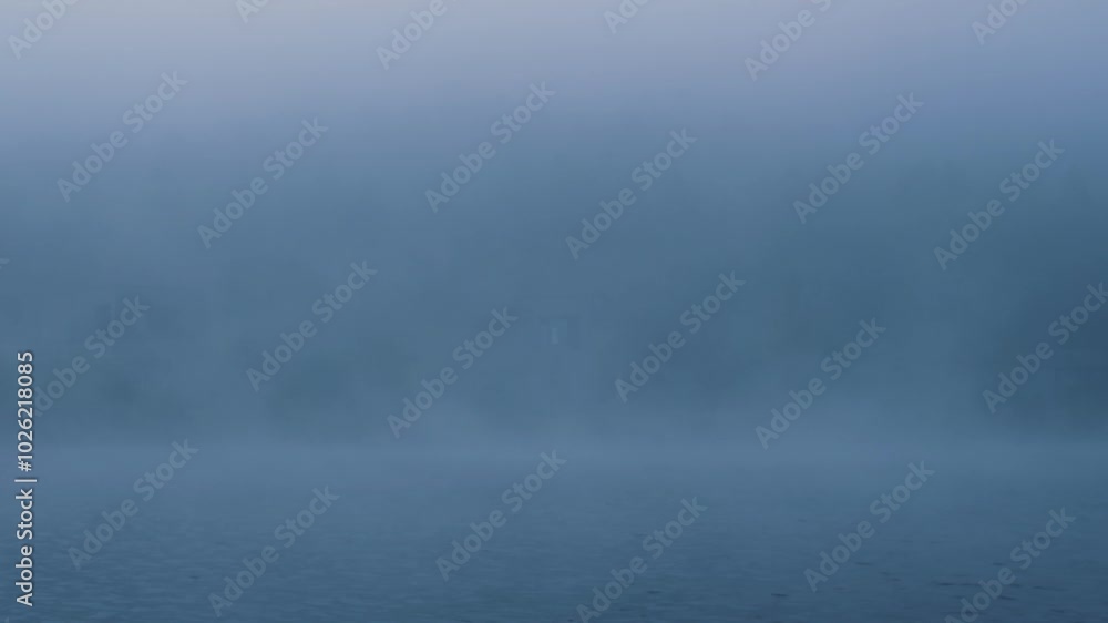 Fog slowly covering the surface of a lake Fog slowly covering the surface of a lake