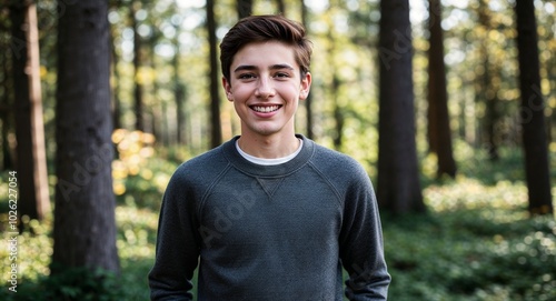 Teen Canadian guy in a casual sweater smiling portrait photo forest background