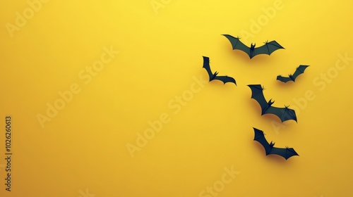 Bats flying against a vibrant yellow backdrop during Halloween-themed decorat...