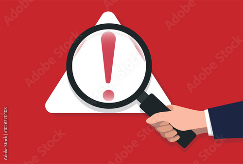 Hand-holding classic magnifier glass with triangle warning sign