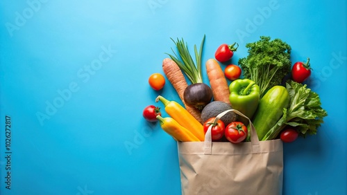 Colorful grocery bag spilling fresh produce on blue background photo