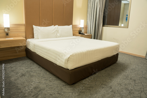 Interior of modern bedroom at hotel with white bed and pillow.