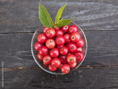 Muntingia calabura or cherries in bowl on the black wooden table  photo