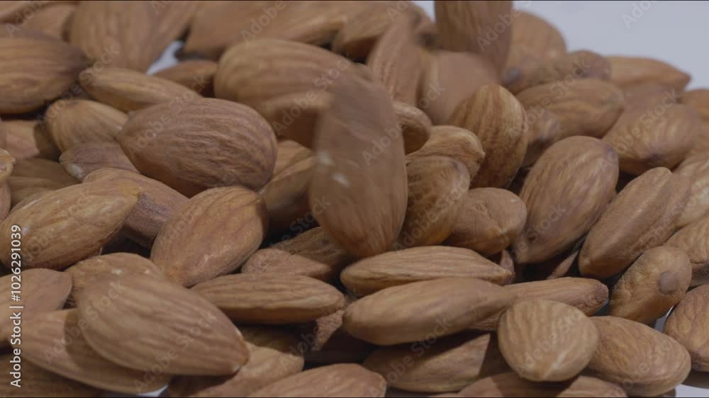 Macro close-up shot of a portion of unshelled almonds and more being placed. Static Macro close-up shot of a portion of unshelled almonds and more being placed. Static