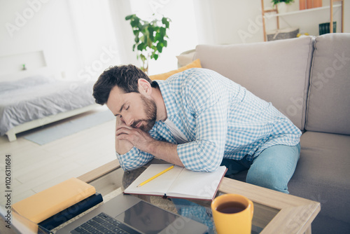 Photo of handsome bearded alone mature age adult man studying at home indoors living room with huge couch sleeping tired during seminar