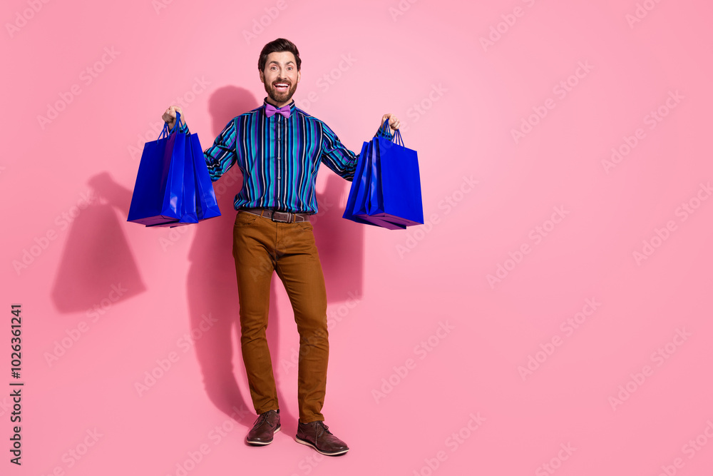 Full length photo of elegant groomed man wear stylish clothes hold packages isolated on pink color background Full length photo of elegant groomed man wear stylish clothes hold packages isolated on pink color background