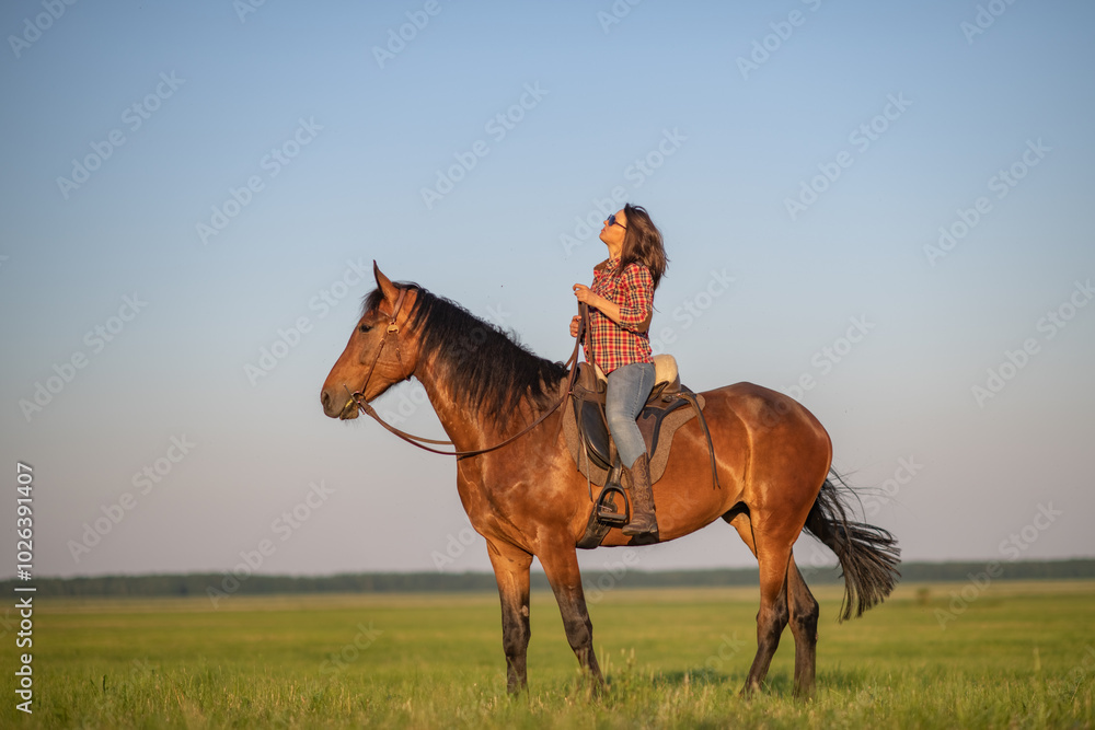 Portrait of a young beautiful dark-haired girl with a horse outdoors.