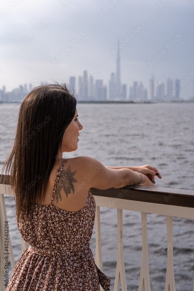 Close-up of young woman on a lookout point overlooking the Dubai skyline. Close-up of young woman on a lookout point overlooking the Dubai skyline.