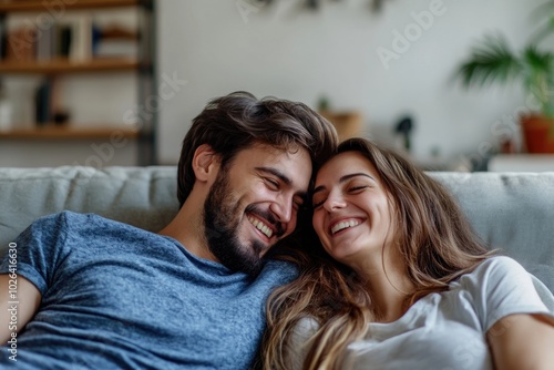 A couple sitting together on a couch, looking relaxed and comfortable