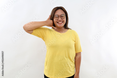 Happy smiling delighted Asian girl with healthy skin shows call me gesture, makes phone hand sign, isolated on white background. Body language. photo