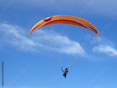 Paraglider flying in a blue sky	 photo