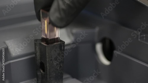 Placing a cuvette into a spectrometer to measure absorbance.