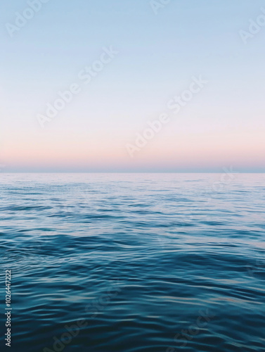 A peaceful ocean scene with gentle waves rippling under a soft sunset sky, creating a calm and tranquil atmosphere.