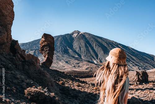 A woman stands in a desert with a mountain Teide in the background photo