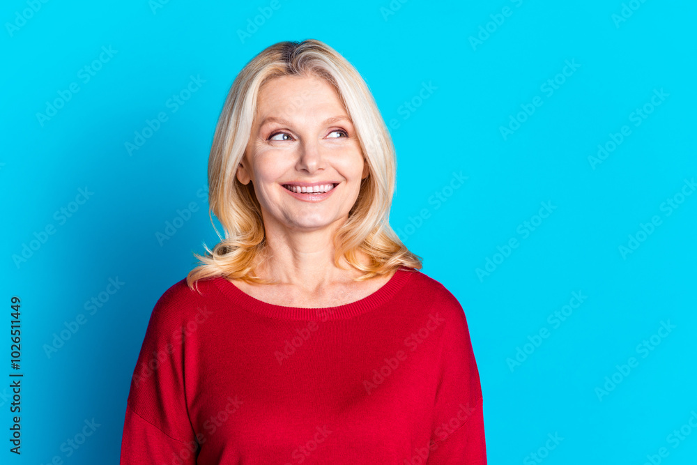 Photo portrait of pretty senior female look empty space wear trendy red outfit isolated on blue color background Photo portrait of pretty senior female look empty space wear trendy red outfit isolated on blue color background