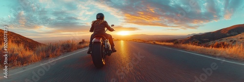 A motorcyclist rides along a winding road at sunset in a picturesque landscape