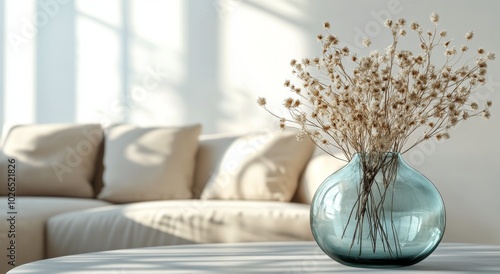 A serene interior scene featuring dried flowers in a blue vase on a wooden table