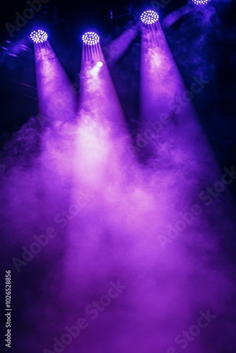 Dramatic purple lighting fills a stage with mist during a theatrical performa...