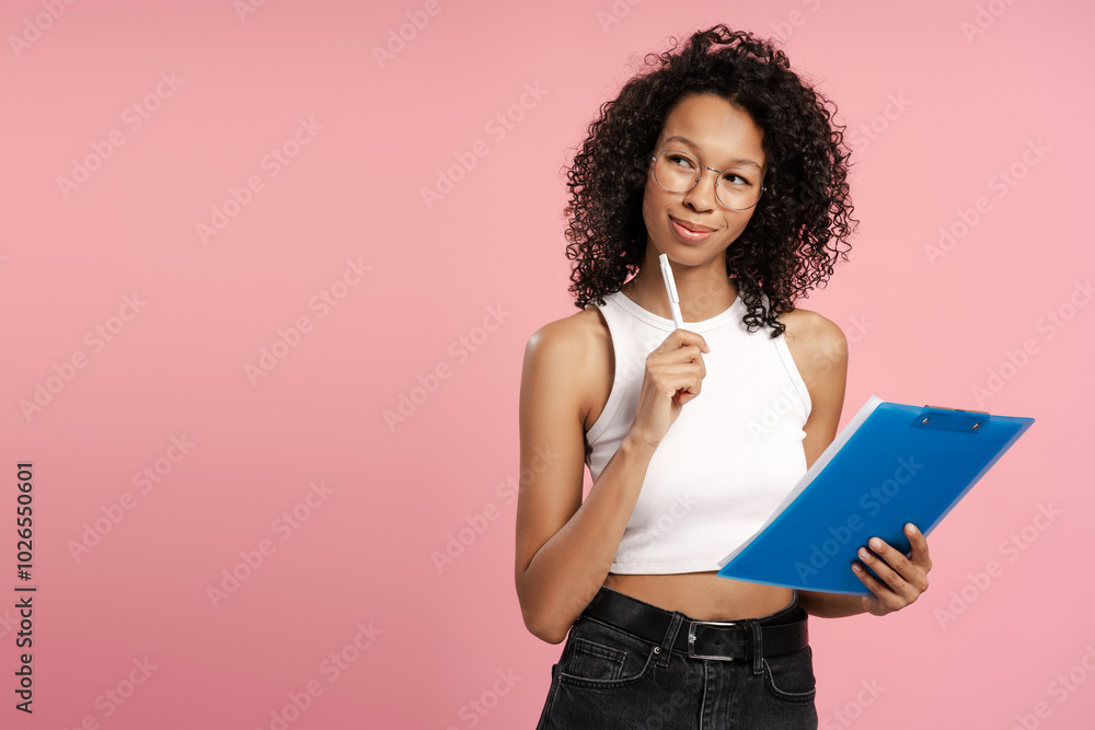 Pretty young African American woman posing with file holder isolated on pink background Pretty young African American woman posing with file holder isolated on pink background