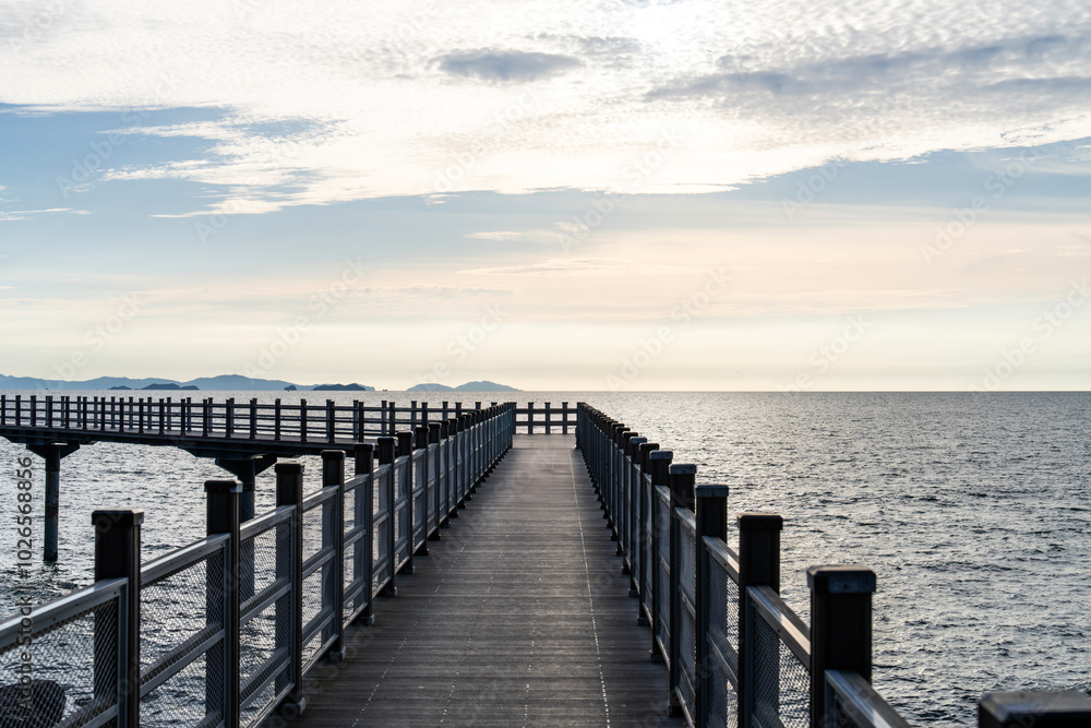 walkway bridge at the seaside during sunset