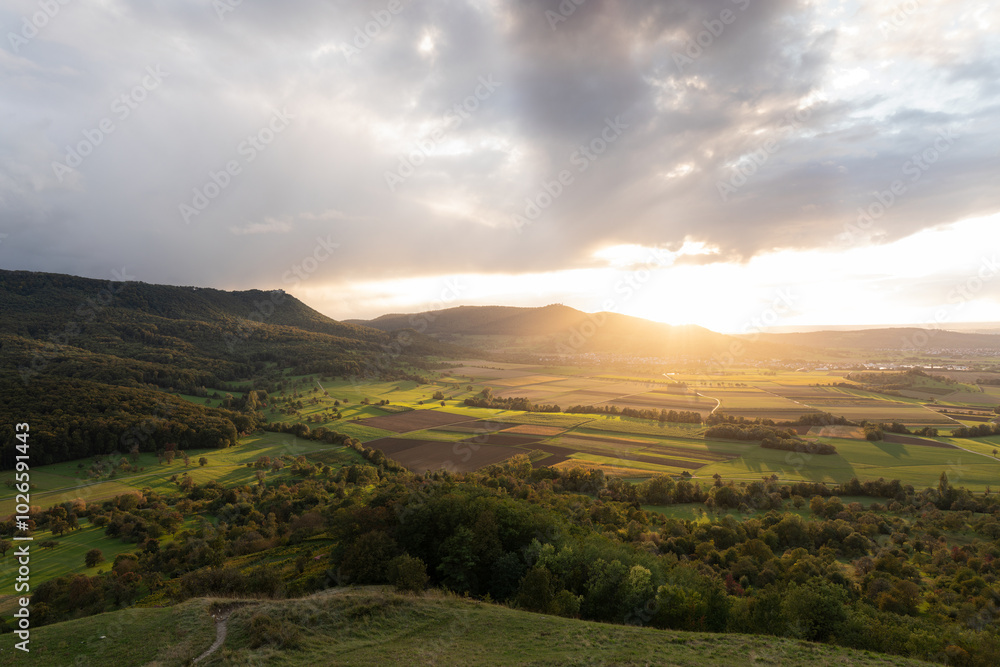 Fototapeta premium Schwäbische Alb bei Weilheim Teck. Sonnenuntergang auf der Limburg. Streuobstwiesen, Wiesen und Felder im schönsten Abendlicht.