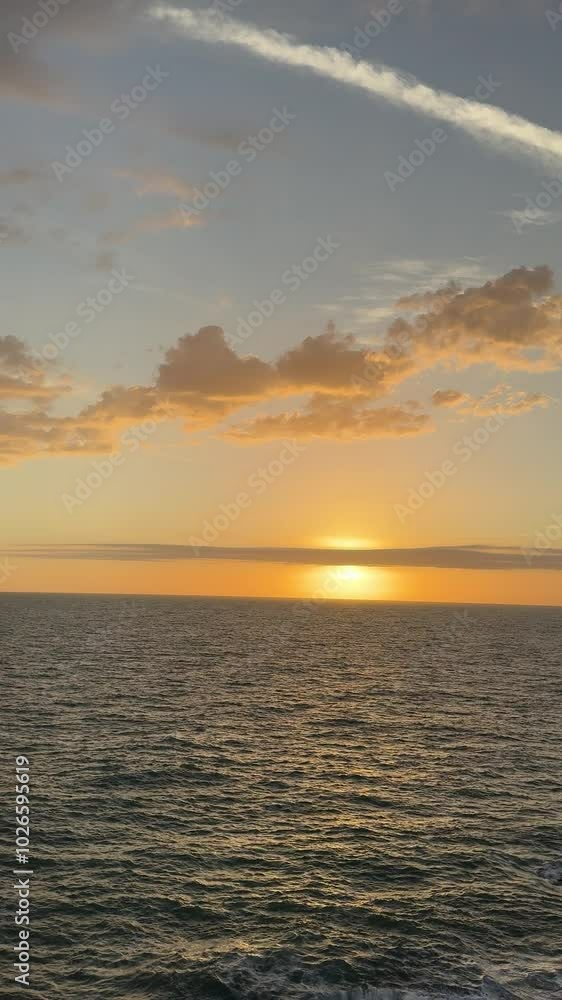 Golden sunset clouds over the ocean, vertical video. Golden sunset clouds over the ocean, vertical video.
