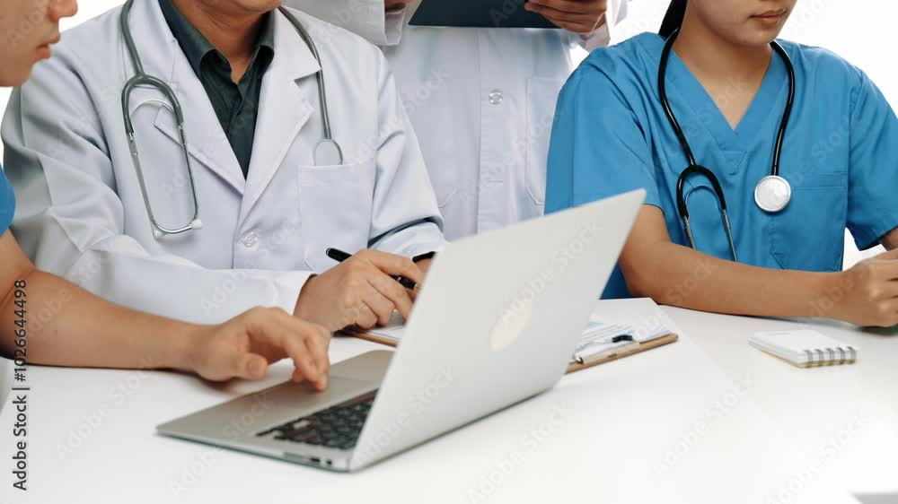 Professional group of medical working and planning medical treatment or healthcare system at hospital table together. Teamwork lead to successful illness and sickness treatment. Slow motion. Rigid. Professional group of medical working and planning medical treatment or healthcare system at hospital table together. Teamwork lead to successful illness and sickness treatment. Slow motion. Rigid.