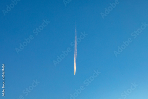 Foto contrail of an aircraft in morning light at blue sky