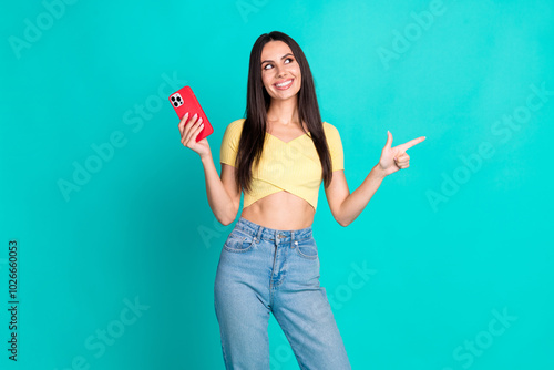 Photo of pretty young woman indicate finger empty space wear top isolated on teal color background photo