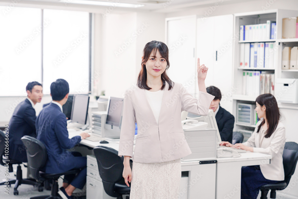 オフィスでポイントを指差す若い女性社員 オフィスでポイントを指差す若い女性社員