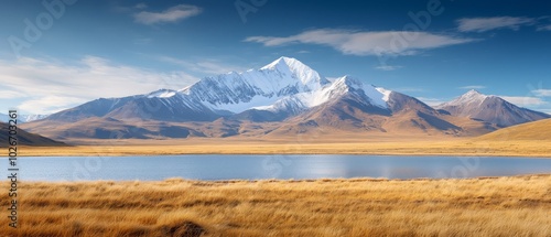  A mountain range with a lake in the foreground and a grassy field beside it