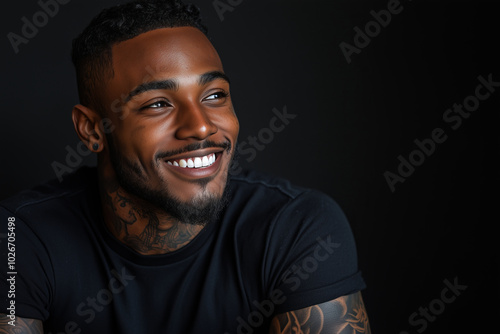 African American man has tattoos on his body on black background.