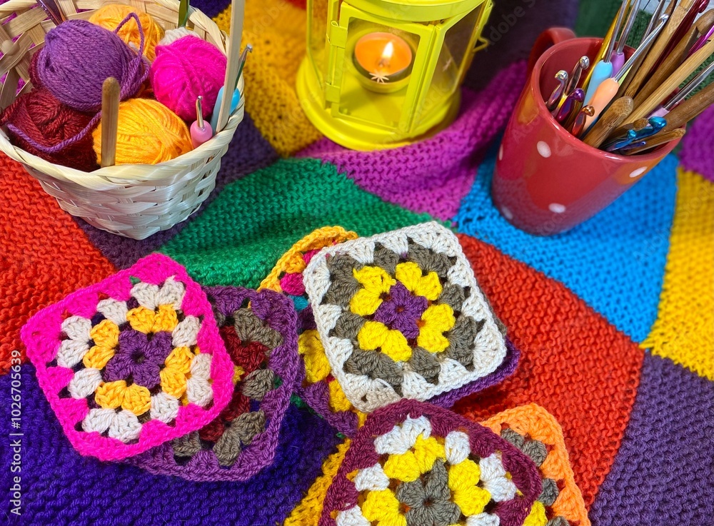 Crochet granny square motives set on the table, clews and hooks and basket cozy home photo Crochet granny square motives set on the table, clews and hooks and basket cozy home photo