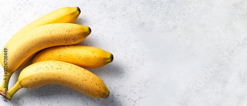  A bunch of ripe bananas atop a white counter, next to a banana peel