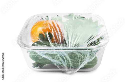 Glass container of fresh vegetables with plastic food wrap isolated on white photo