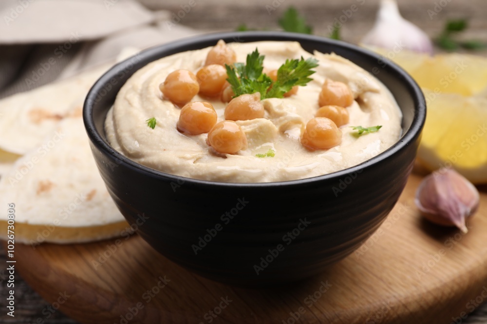 Delicious hummus with chickpeas and pita served on wooden table Delicious hummus with chickpeas and pita served on wooden table