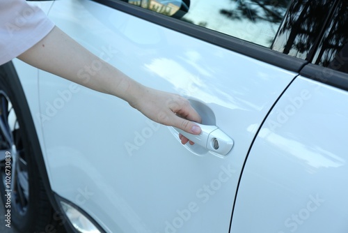 Woman opening door of white car outdoors, closeup