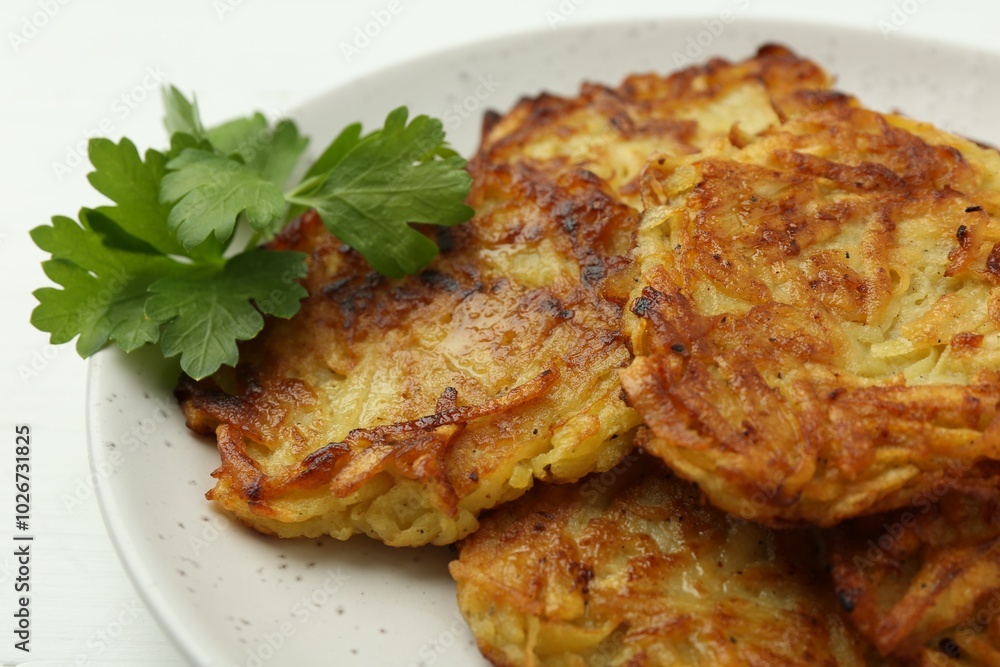 Delicious potato pancakes and parsley on table, closeup Delicious potato pancakes and parsley on table, closeup